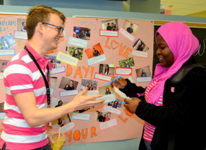 Student and staff in pink shirts shake hands
