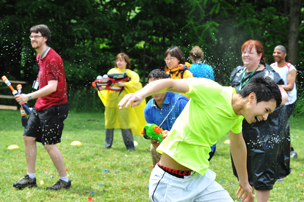 A group of students outside having a watergun fight.