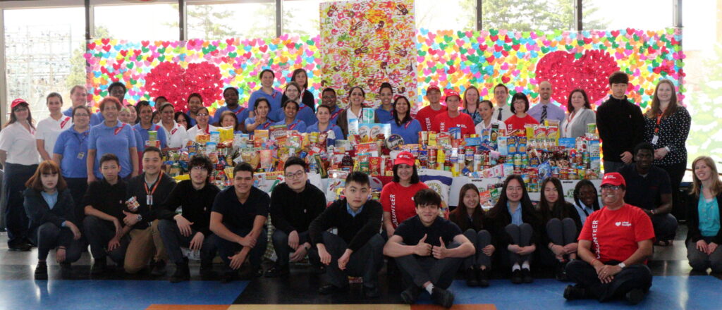 Students and staff pose with non-perishable donations
